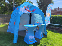 Un beachflag personnalisé à côté d'autre matériel promotionnel pour Aviation4Kids