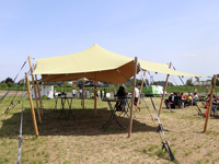 Tonnelle très belle avec toile extensible en beige, et des poteaux en bois (non inclus).